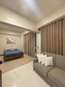 un soggiorno con un divano e un letto di The Mactan Suite at The Mactan Newtown Resort a Punta Engaño