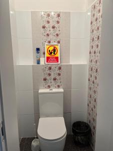 a bathroom with a toilet with a sign above it at Korkem in Shymkent