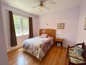 a bedroom with a bed and a ceiling fan at Tip-of-Peninsula Lookout Cottage in Tobermory