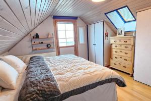 ein Schlafzimmer mit einem großen Bett im Dachgeschoss in der Unterkunft Fiskarvillan in Simrishamn