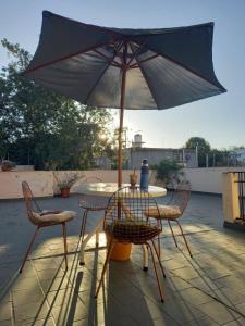a table and chairs with an umbrella on a patio at Departamento 3 habitaciones in Salta
