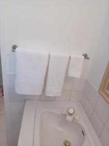 a white toilet in a bathroom with towels at Peaceful Home With Private Pool! in Montego Bay