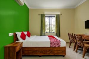 - une chambre dotée d'un lit avec un mur vert dans l'établissement OYO Kakkanad Heights Inn, à Kakkanad