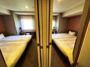 two beds in a small room with two beds sidx sidx sidx at HOTEL SUI AKASAKA by ABEST in Tokyo