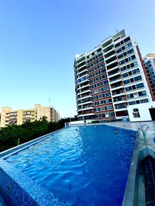 une grande piscine en face d'un bâtiment dans l'établissement Luxury Apartment Palm Village By Brills, à Dar es Salaam