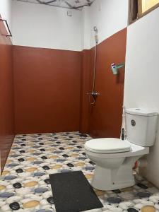 a bathroom with a toilet and a tile floor at Himansa Homestay in Ella