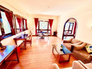 Ramayan Resort, in City Centre Manali By Ramanand Sagar في مانالي: غرفة معيشة مع أريكة وطاولة