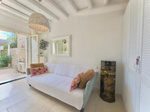 Grace Villa Mykonos في مدينة ميكونوس: غرفة معيشة مع أريكة بيضاء ونافذة