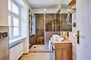 a bathroom with a sink and a shower at Hotel Zur Post Altötting in Altötting