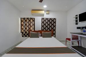 ein Schlafzimmer mit einem großen weißen Bett in einem Zimmer in der Unterkunft Collection O CHITRA LODGE 
