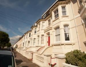 una fila de casas blancas en una calle de la ciudad en Sunny Seaside Sanctuary - Two Bedroom Apartment en Brighton & Hove