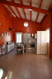 eine große Küche mit weißen Geräten und roten Wänden in der Unterkunft VILLA ROBERTA in San Cono
