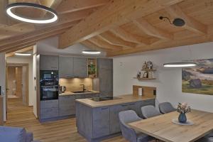 een keuken met houten plafonds en een houten tafel bij Apartment Hoamat in Fulpmes