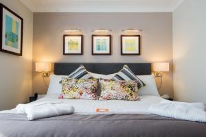 a bedroom with a large white bed with pillows at voco Oxford Spires by IHG in Oxford