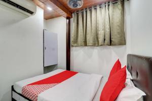 a small bedroom with a bed and a window at Hotel Memsaab Family Residency in Mumbai