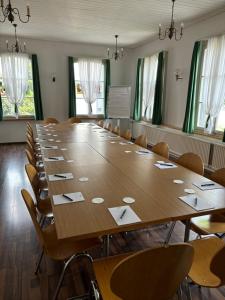 una gran sala de conferencias con una mesa grande y sillas en Hotel Krone Uetendorf, en Uetendorf