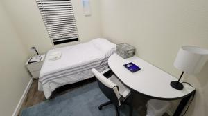 a hospital room with a bed and a table with a lamp at San Jose Shark House - Unit 1 in San Jose