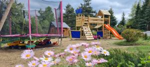 - un parc avec une aire de jeux dotée d'un toboggan et de fleurs dans l'établissement Villa Paradajs - ubytovanie pri jazere, à Banská Štiavnica