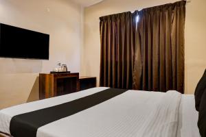 a hotel room with a bed and a television at Collection O Hotel Nanashree Grand in Pune