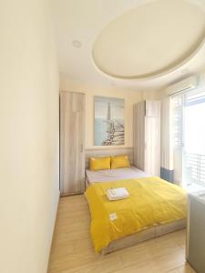 The HogWarts Hostel في مدينة هوشي منه: غرفة نوم بسرير اصفر ونافذة كبيرة