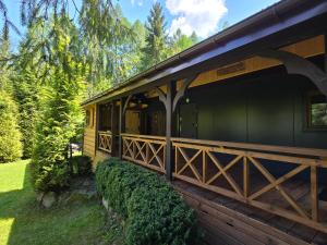 uma cabana na floresta com uma cerca e árvores em Domek nad Potokiem em Koninki