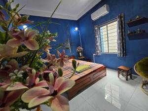 a bedroom with blue walls and a bed with pink flowers at alley homestay in Hanoi