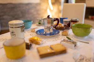 uma mesa com um bule de chá e alguma comida sobre ele em Verdemare em Duino