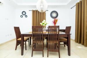ein Esszimmer mit einem Holztisch und Stühlen in der Unterkunft Stay Play Away Residences - Luxury 4 bed, Airport Residential, Accra in Accra