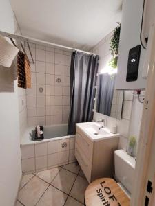 La salle de bains est pourvue d'une baignoire, d'un lavabo et d'une douche. dans l'établissement T3 vue superbe à 5 mns de la plage avec wifi parking gratuit, au Barcarès