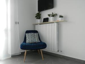 a blue chair sitting in front of a radiator at Lago Maggiore holiday house, lake view, Vignone in Dumenza