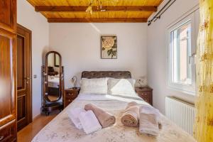 a bedroom with a large bed with towels on it at Villa Edem in Kassiopi
