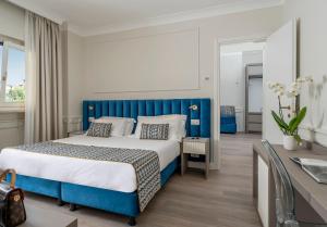 una camera da letto blu e bianca con letto e scrivania di Hotel Michelangelo a Sorrento