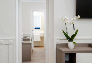een badkamer met een tafel met een vaas met bloemen bij Hotel Michelangelo in Sorrento