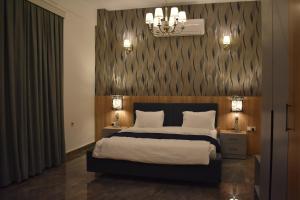a bedroom with a large bed and two night stands with lamps at Motel Victoria Sky in Erbil