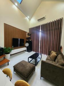 uma sala de estar com um sofá e uma televisão em Chapi’s Home em Ilha de Cát Bà