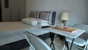 Habitación con cama y mesa con sillas. en Cozy Studio Kuala Lumpur by LH, en Kuala Lumpur