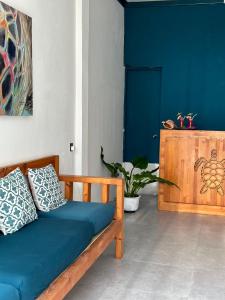 a blue couch in a room with a blue wall at Bougainvillea Inn - Maldives in Fulidhoo
