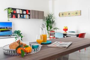 a table with a tray of food and orange juice at Tomasi Apartment Palermo in Palermo +20 photos