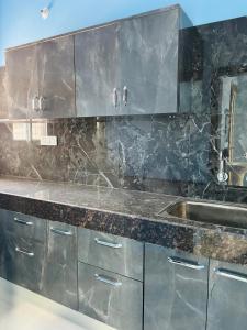 a kitchen with stainless steel cabinets and a sink at Sumitralay Bhawan in Rānchī