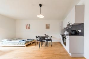 uma cozinha com uma mesa e cadeiras e uma cama em Muzeta Graz - Eco-Friendly Parkview Holiday Apartments in Graz’s Smart City em Graz