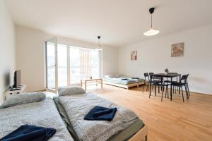 uma sala de estar com duas camas e uma mesa em Muzeta Graz - Eco-Friendly Parkview Holiday Apartments in Graz’s Smart City em Graz