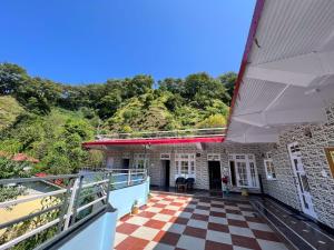 a balcony of a building with a checkered floor at Rocky Mountain homestay in Dalhousie