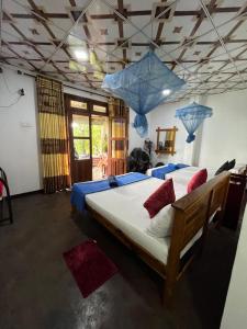 a bedroom with a large bed with blue lamps at Himansa Homestay in Ella