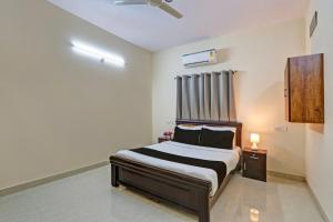1 dormitorio con 1 cama y ventilador de techo en Super OYO Sri Nirvana Edge, en Ameerpet