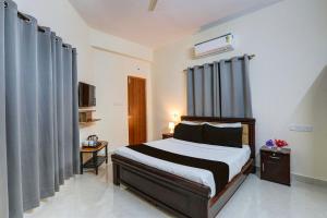 a bedroom with a bed with black and white sheets at Super Collection O Sri Nirvana Edge in Hyderabad