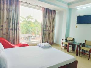 een hotelkamer met een bed en een raam bij Nhà nghỉ thảo ngân in Bình Mỹ