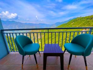 2 Stühle und ein Tisch auf einem Balkon mit Aussicht in der Unterkunft Kamlesh Lodge in Bhavnagar