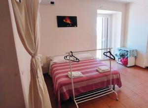 1 dormitorio con 1 cama con manta de rayas roja y blanca en Villa Egle Belpasso, villa vacanza con piscina, en Belpasso