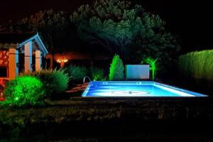 a swimming pool at night with green lights at Casita Adosada con jardín en Finca privada en Baix Empordà in L'Estartit