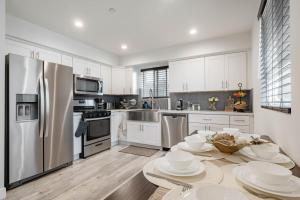 a kitchen with white cabinets and stainless steel appliances at Modern NOHO Gem! in Los Angeles